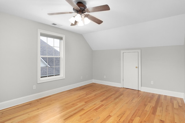 additional living space with light hardwood / wood-style floors, vaulted ceiling, and ceiling fan