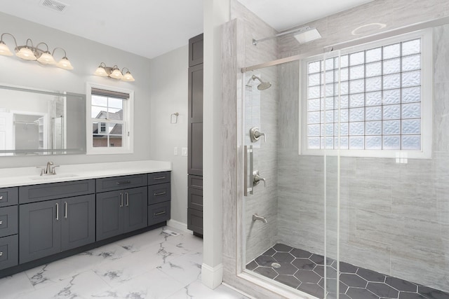 bathroom with vanity, a healthy amount of sunlight, and walk in shower