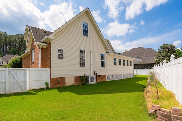 back of house with ac unit and a lawn