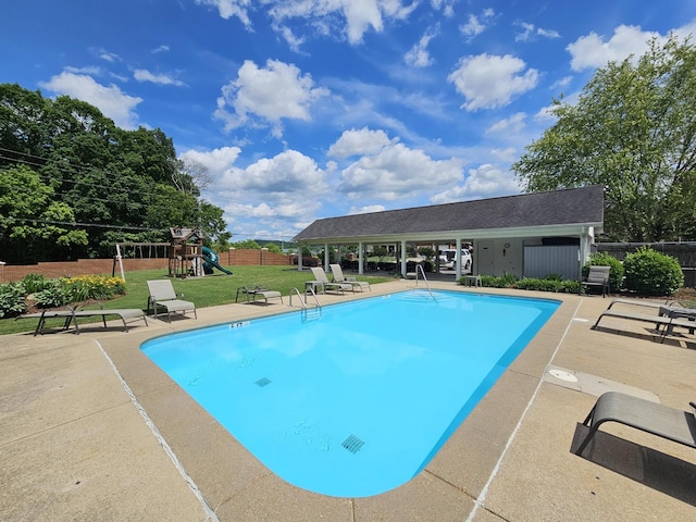 view of pool with a yard, a patio, and a playground