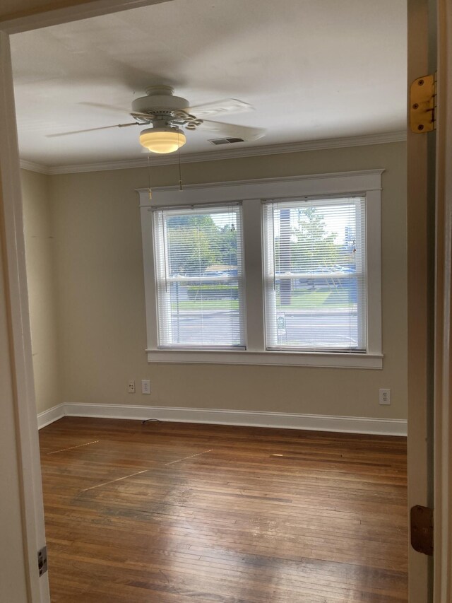 spare room with dark hardwood / wood-style flooring, ceiling fan, and crown molding