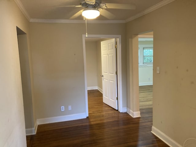 empty room with crown molding, ceiling fan, dark wood finished floors, and baseboards