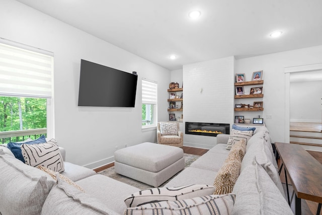 living room with hardwood / wood-style flooring and a large fireplace