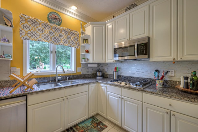 kitchen featuring white cabinetry, sink, a textured ceiling, light tile patterned floors, and appliances with stainless steel finishes