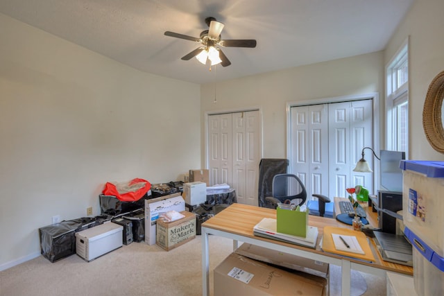 home office with ceiling fan and light carpet