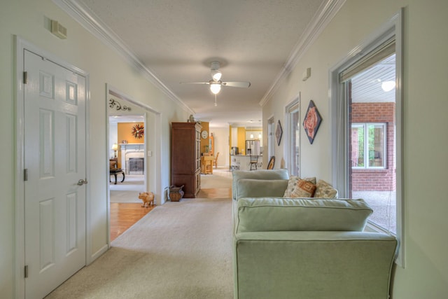 interior space featuring a textured ceiling, ceiling fan, carpet floors, and crown molding