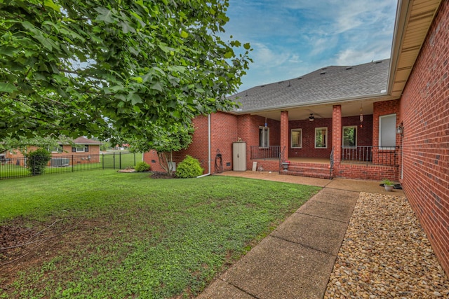 view of yard with a porch and ceiling fan