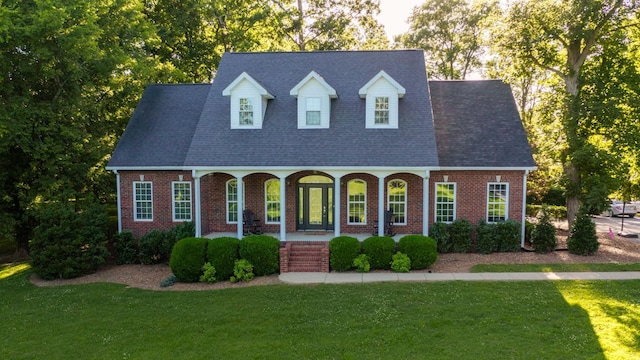 cape cod-style house with covered porch and a front lawn