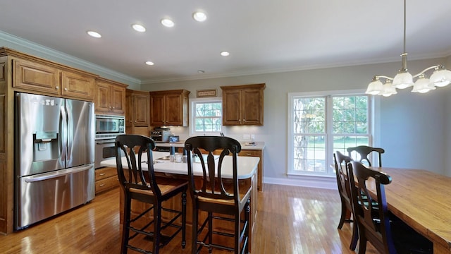 kitchen featuring a chandelier, pendant lighting, light wood-type flooring, and stainless steel appliances