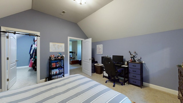 bedroom featuring light carpet, a walk in closet, a closet, and lofted ceiling