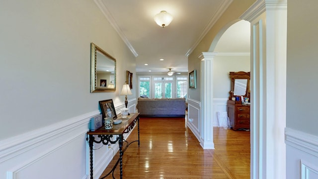 hallway featuring decorative columns, french doors, wood-type flooring, and ornamental molding