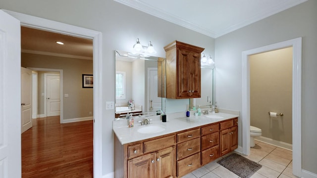 bathroom featuring toilet, vanity, tile patterned floors, and ornamental molding