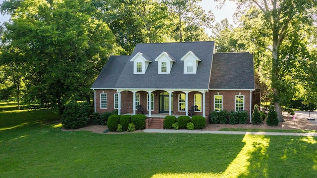 new england style home featuring a front lawn and covered porch