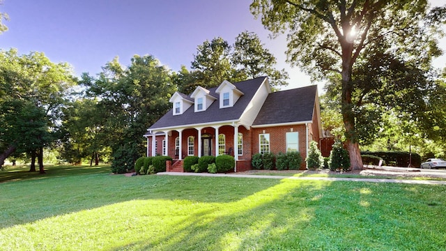 cape cod house with a porch and a front yard