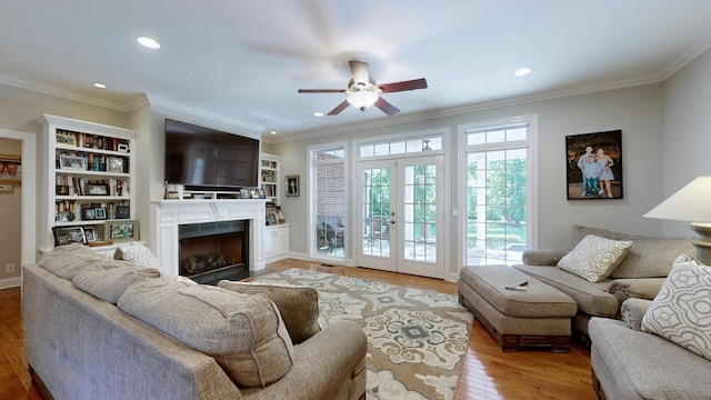 living room with ceiling fan, hardwood / wood-style floors, french doors, and ornamental molding