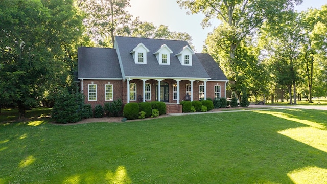 cape cod house with covered porch and a front lawn