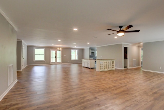 unfurnished living room featuring light wood-type flooring, ceiling fan with notable chandelier, and ornamental molding