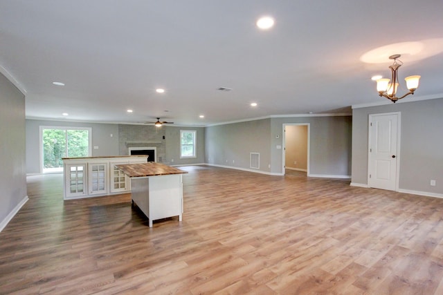 kitchen featuring a fireplace, light hardwood / wood-style flooring, and crown molding