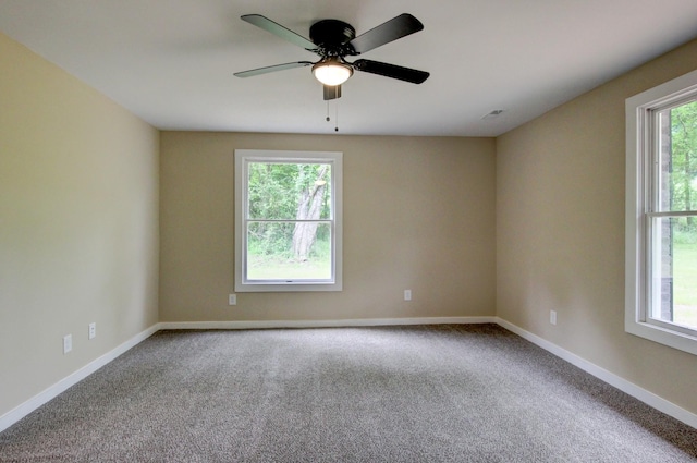 empty room featuring a wealth of natural light, carpet, and ceiling fan