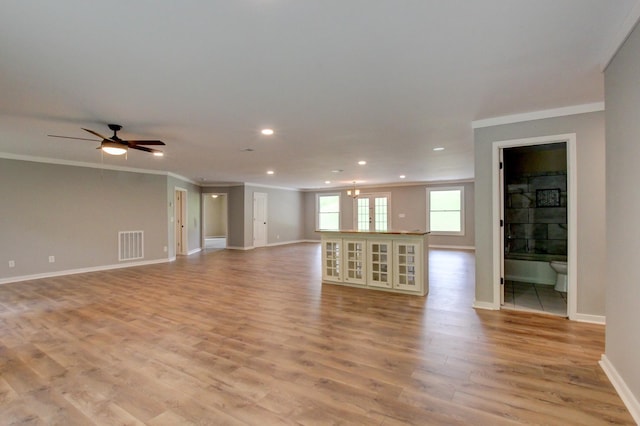 unfurnished living room with french doors, light hardwood / wood-style floors, ceiling fan, and crown molding