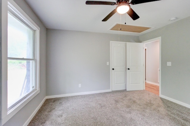 spare room with a healthy amount of sunlight, ceiling fan, and light colored carpet