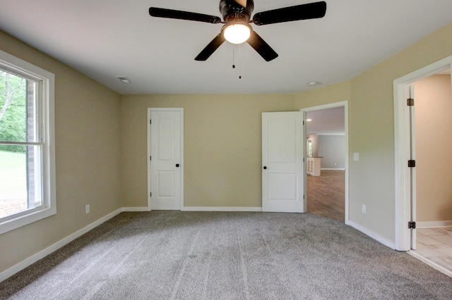 unfurnished bedroom featuring light carpet and ceiling fan