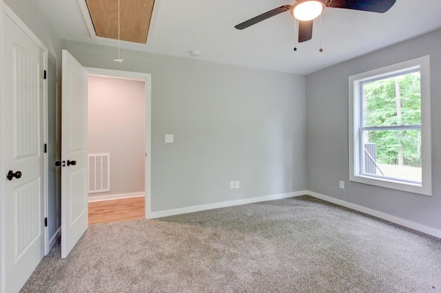 carpeted spare room featuring ceiling fan