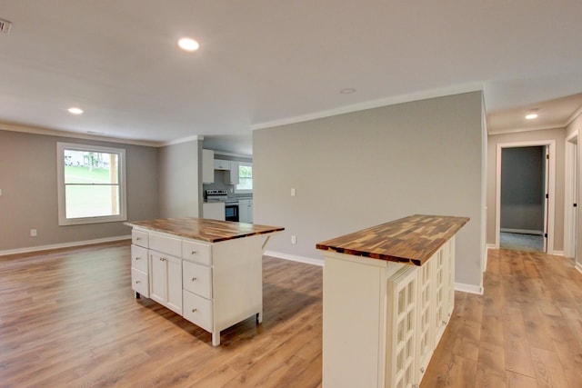 kitchen featuring white cabinets, a kitchen island, and butcher block counters