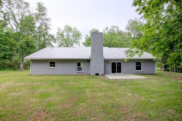 rear view of house with a yard and a patio