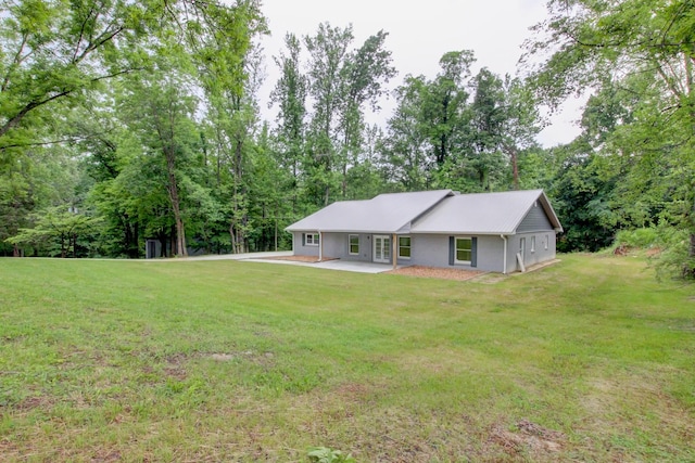 back of house featuring a patio area and a yard