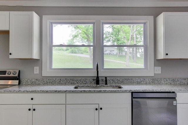 kitchen featuring stainless steel appliances, white cabinetry, plenty of natural light, and sink