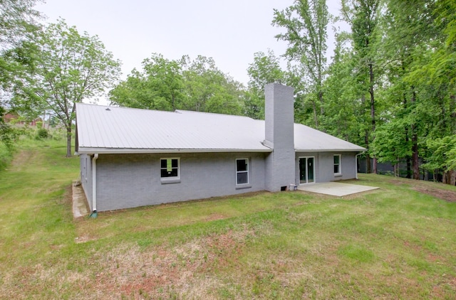 back of house with a lawn and a patio