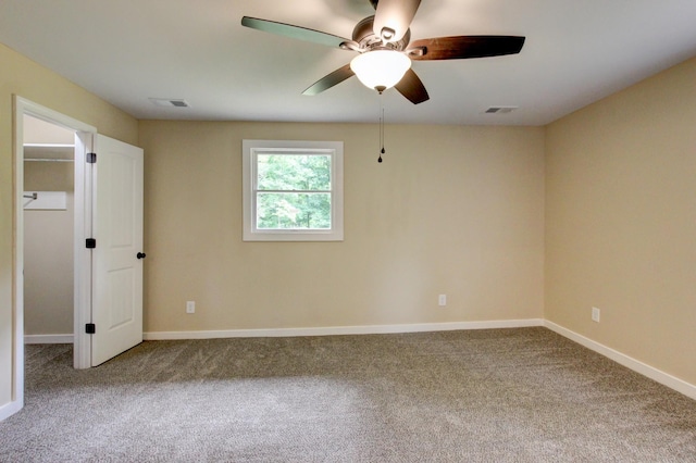 carpeted spare room featuring ceiling fan