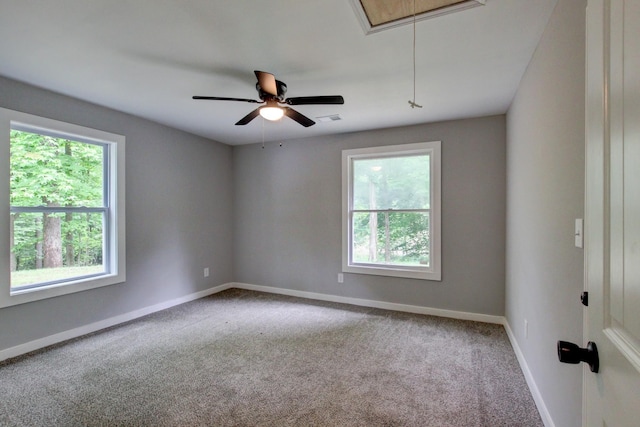 carpeted spare room featuring a wealth of natural light and ceiling fan