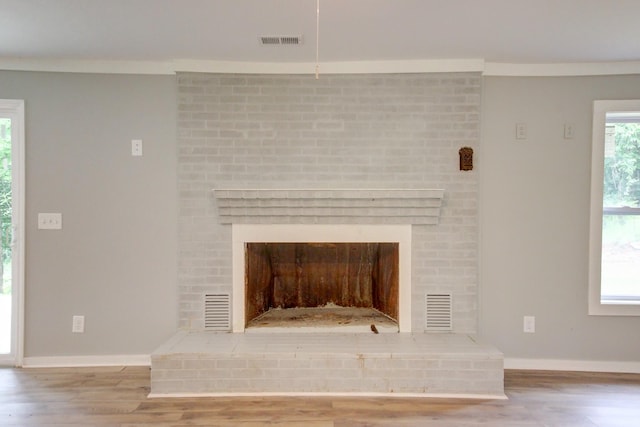 interior details with crown molding, wood-type flooring, and a fireplace