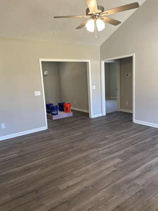 empty room featuring ceiling fan, lofted ceiling, dark hardwood / wood-style flooring, and a textured ceiling