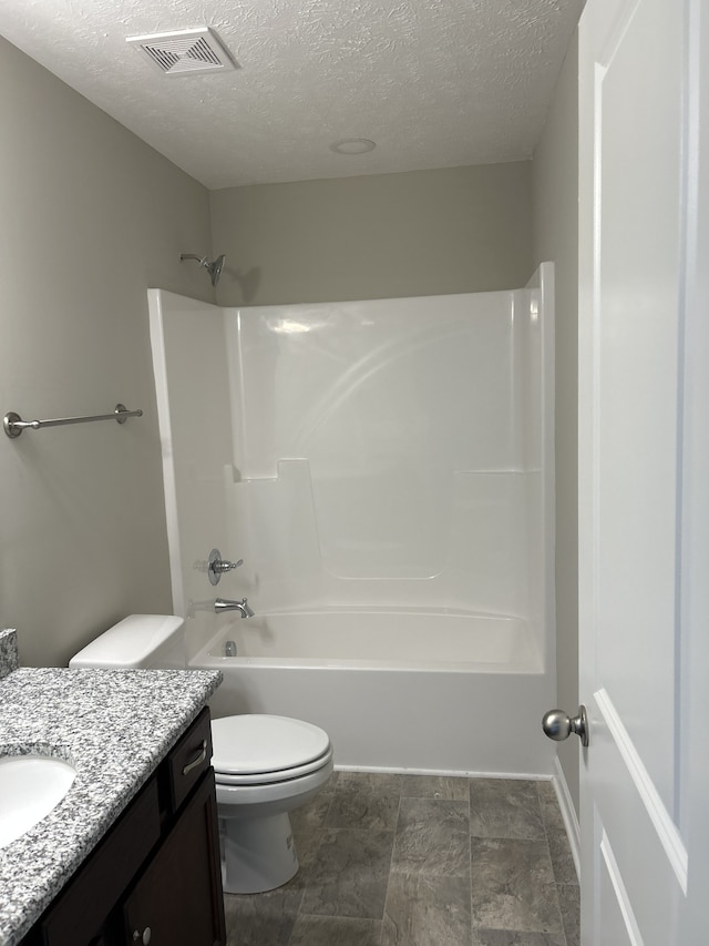 full bathroom featuring vanity, a textured ceiling,  shower combination, and toilet