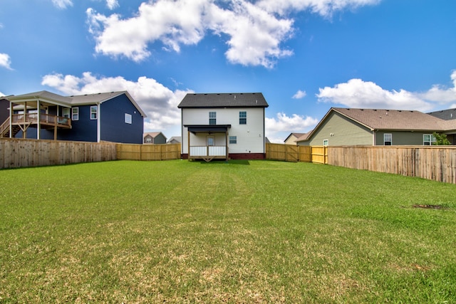 rear view of property featuring a lawn