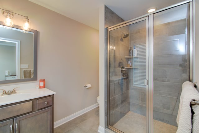 bathroom with toilet, vanity, tile patterned floors, and a shower with door