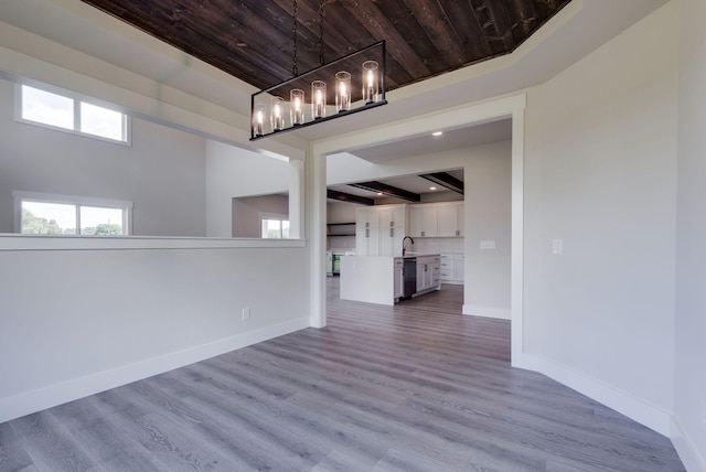 interior space featuring beamed ceiling, a chandelier, wooden ceiling, and light hardwood / wood-style flooring