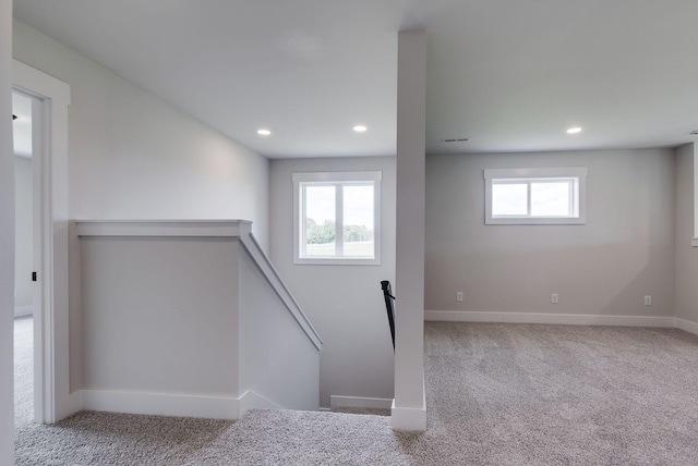 stairway featuring a wealth of natural light and carpet floors