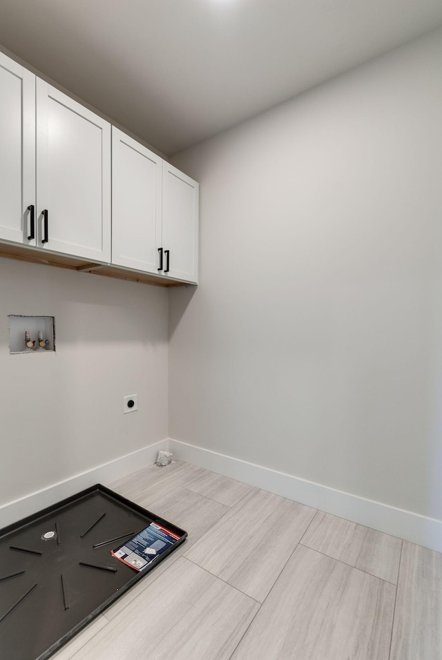 washroom featuring cabinets, hookup for a washing machine, and hookup for an electric dryer