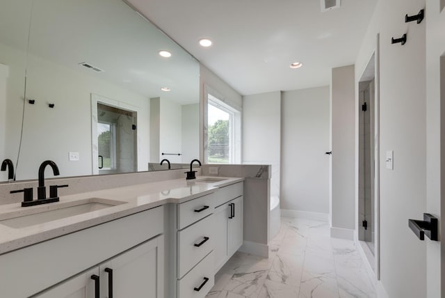 bathroom with vanity and shower with separate bathtub