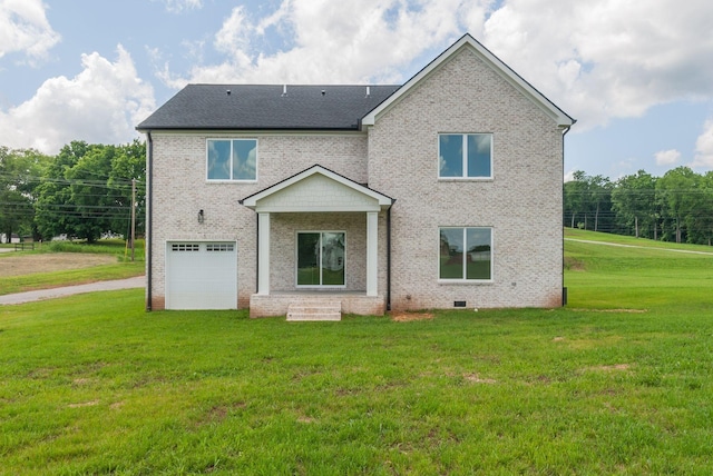 rear view of house featuring a garage and a yard