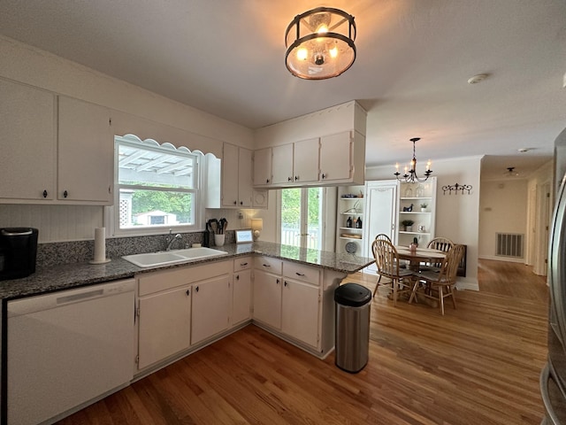 kitchen featuring white cabinetry, sink, kitchen peninsula, white dishwasher, and light hardwood / wood-style floors