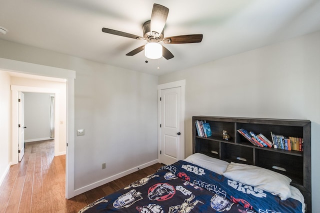 bedroom with ceiling fan, baseboards, and wood finished floors