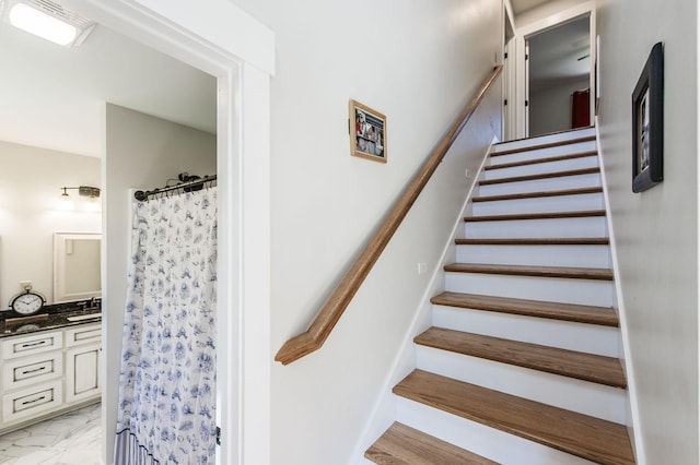 stairway featuring marble finish floor