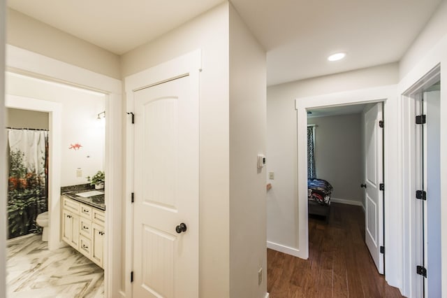 corridor with recessed lighting, wood finished floors, and baseboards