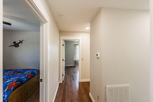 hallway featuring dark wood-style flooring, recessed lighting, visible vents, and baseboards