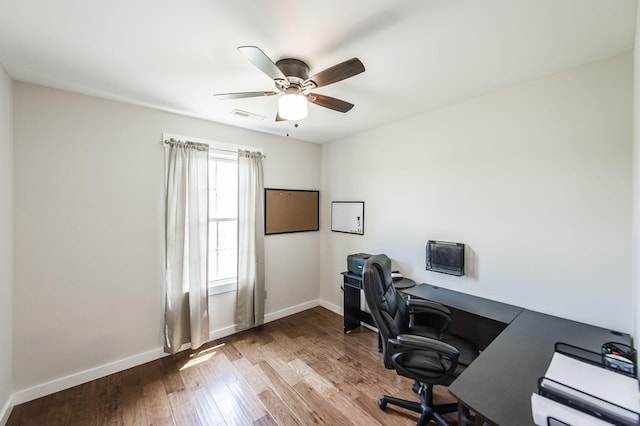 office featuring ceiling fan, wood finished floors, visible vents, and baseboards